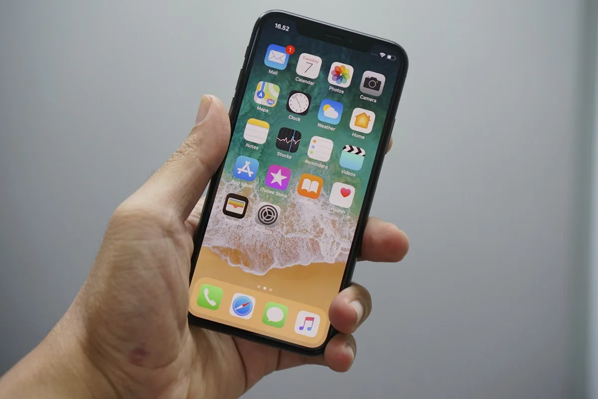 iPhone hardware on a desk—illustrative context for an iOS software update story, not supplied by Apple and not depicting iOS 26.5-specific UI.