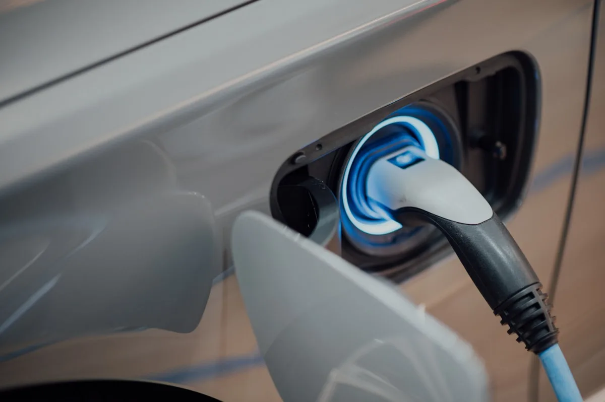 Electric vehicle charging against a twilight sky—context imagery for Newsorga’s comparison of today’s production traction batteries with 2026 solid-state and sodium-ion research lanes.
