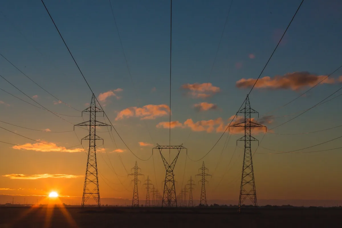Electricity transmission towers at dusk—illustrative context for UK retail energy market consolidation, not a specific E.ON or Ovo facility.