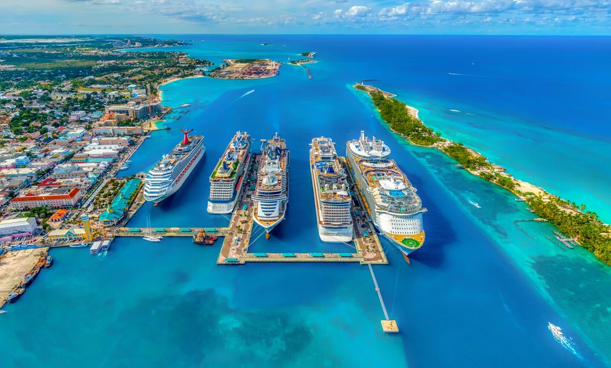 Large cruise ship docked at a port with security presence nearby