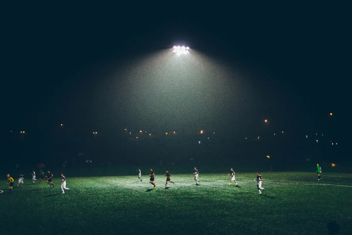 Football stadium floodlights and stands during an evening match