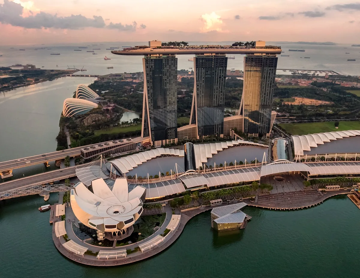 Singapore Marina Bay skyline at dusk with the Sands integrated resort and downtown financial district lit up, illustrative backdrop for the Milken Institute's 2026 Global Opportunity Index in which Singapore ranks 7th globally