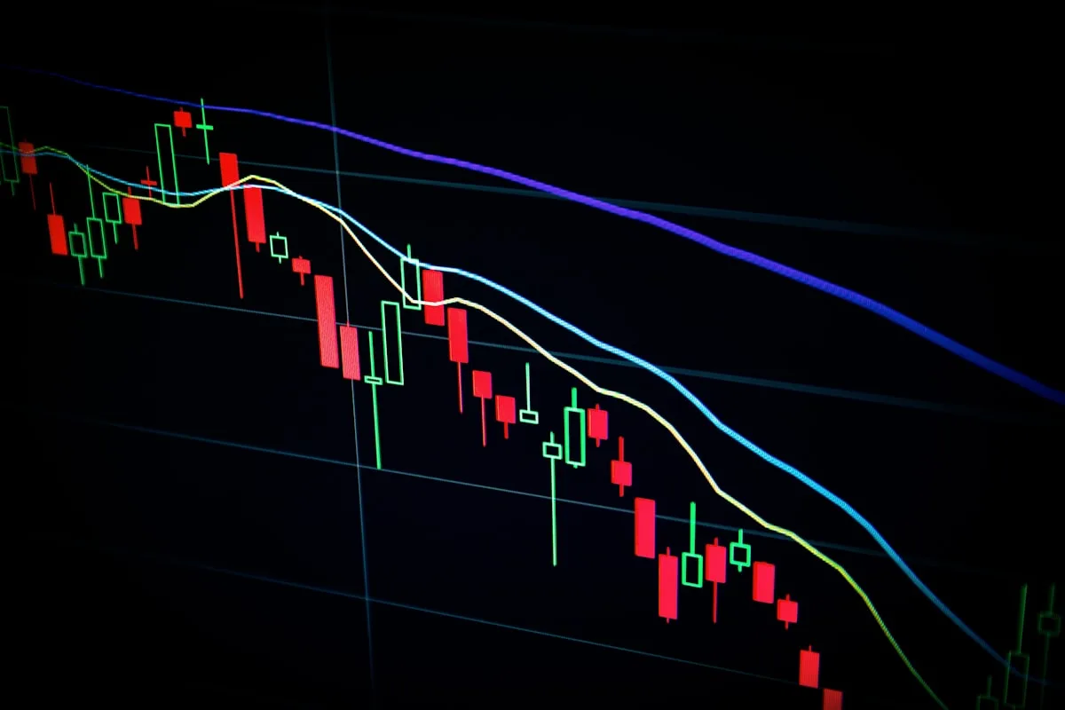 Stylised aerial view of stock-market trading data displayed across multiple monitors and ticker tapes — illustrative imagery for Newsorga's analysis of how the blockchain-based prediction market Polymarket has become Wall Street's structured 'third opinion' alongside sell-side analyst consensus and economist survey consensus, following Intercontinental Exchange's completed $2 billion equity commitment at a $9 billion valuation and the February 2026 launch of the ICE Polymarket Signals and Sentiment tool feeding crowd-sourced probability data into the same ICE Consolidated Feed that distributes NYSE equity prices.