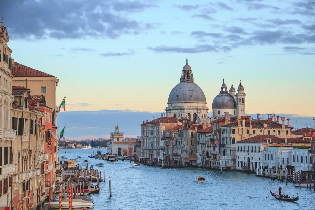 Venice canal at sunset with the Salute basilica skyline, illustrative backdrop for the 61st Venice Biennale and its political controversies